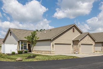 A house with a white garage door and a brown roof.